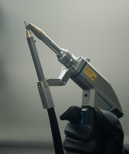 hand holding agains a gray background a laser welding torch